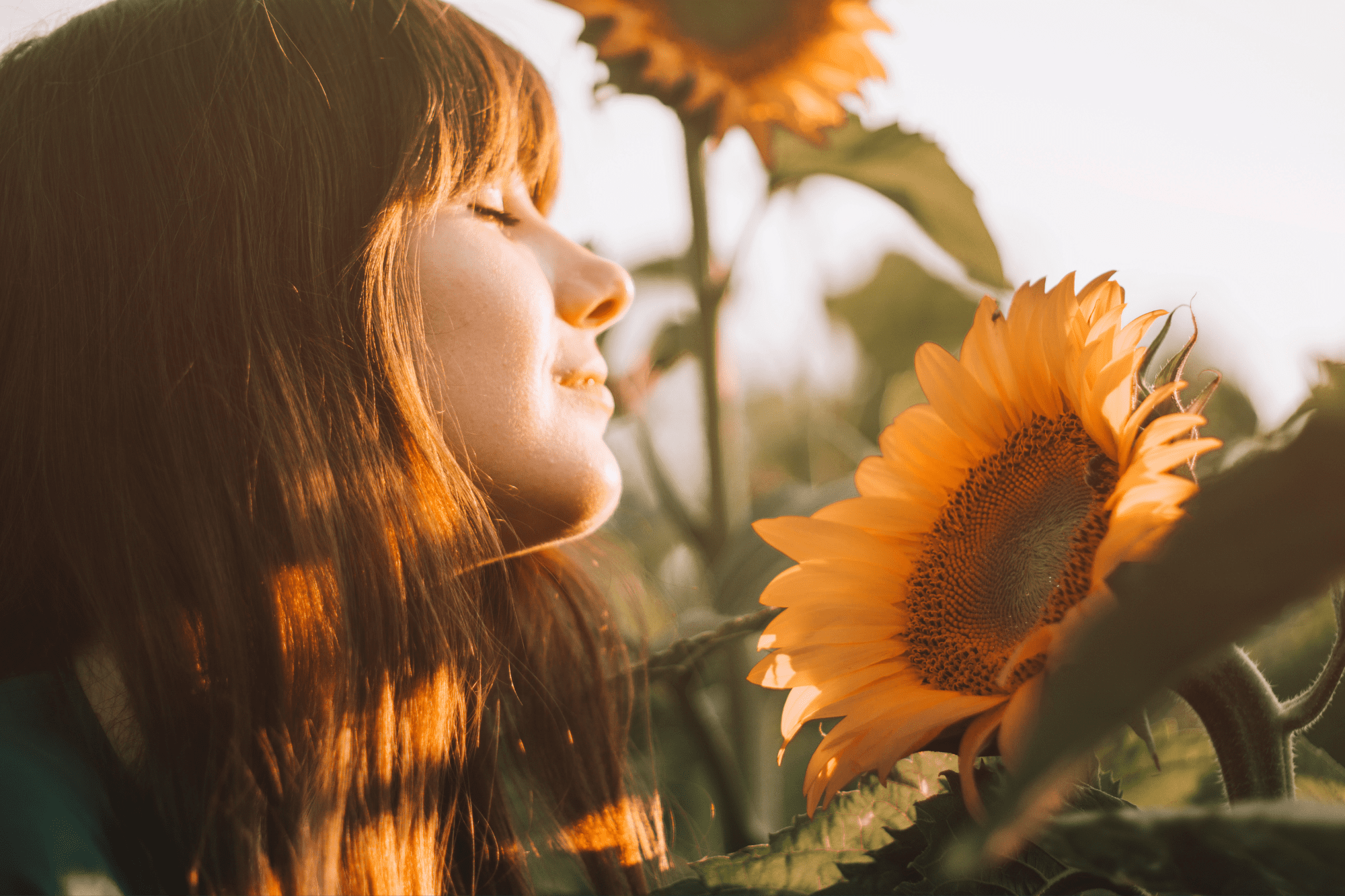White woman smells a sunflower
